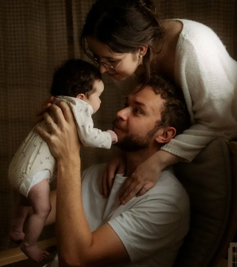 Parents admirant leur nouveau-né lors d'une séance naissance en studio - Melissa Jai Photographe