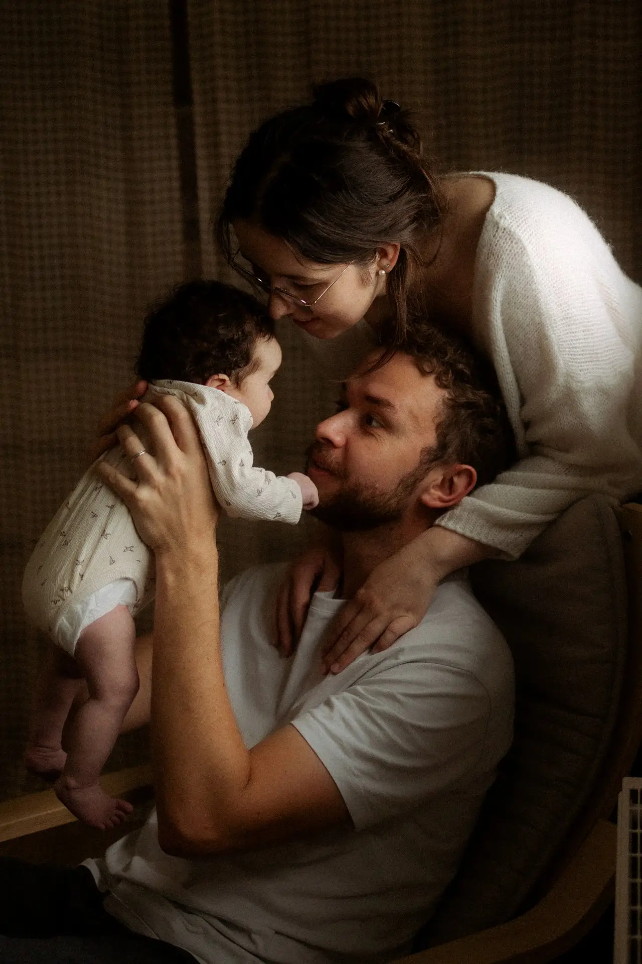 Parents admirant leur nouveau-né lors d'une séance naissance en studio - Melissa Jai Photographe