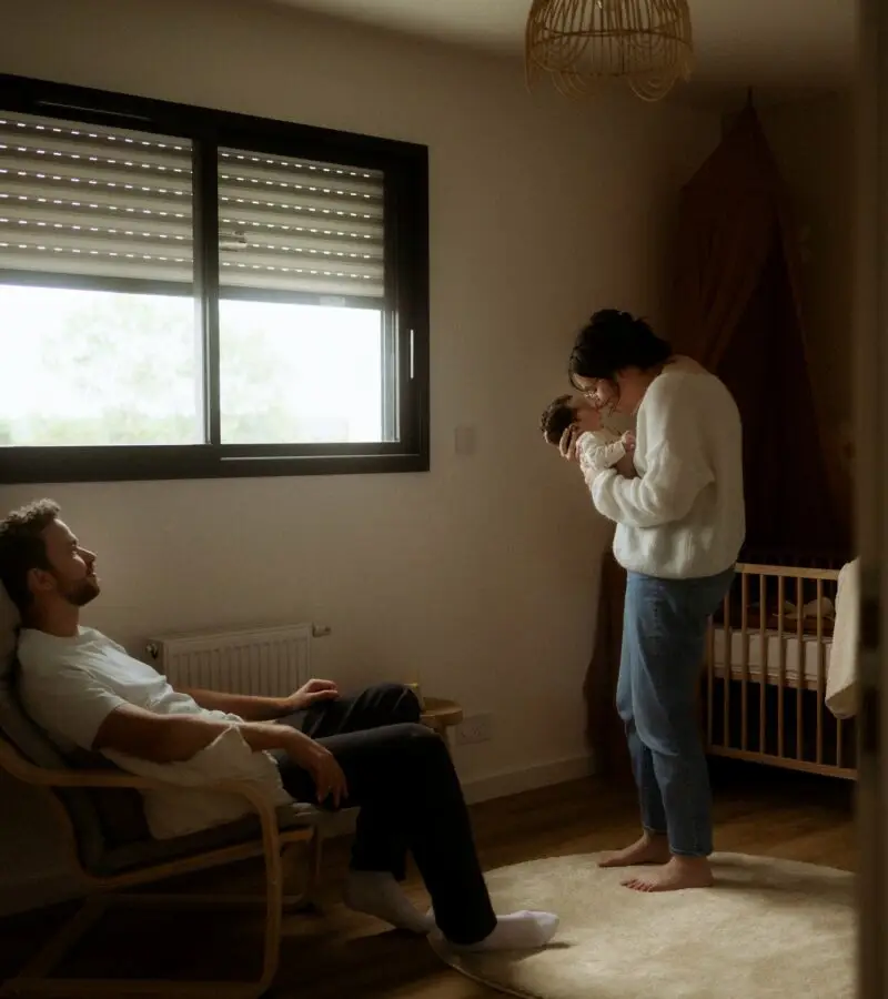 Parents avec leur nouveau-né dans la chambre de bébé lors d'une séance naissance à domicile - Melissa Jai Photographe