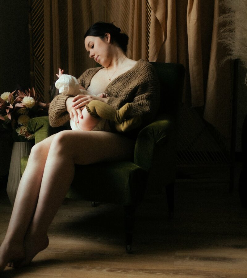 Seance photo allaitement maman allaitant bebe sur fauteuil en studio avec herbes de pampa photographe Melissa Jai