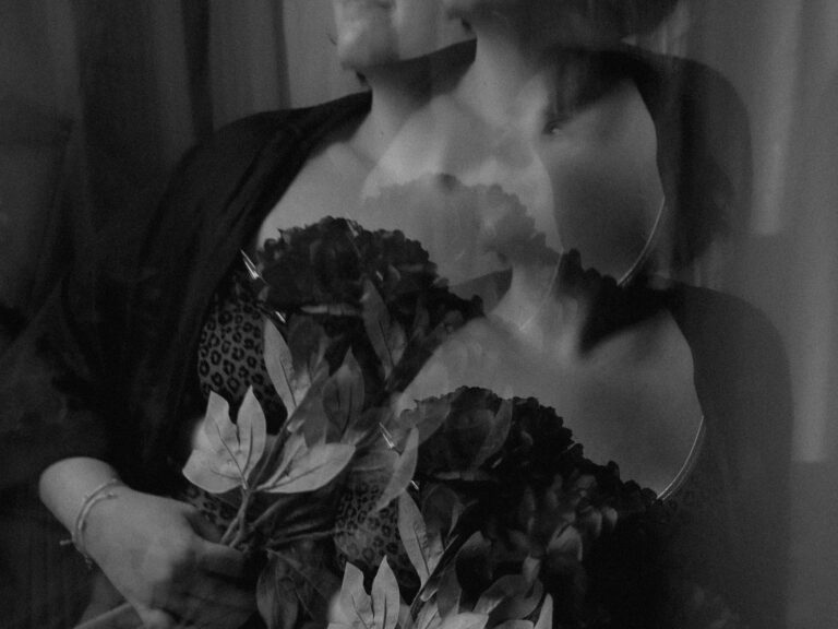 Portrait artistique en noir et blanc avec effet double exposition d'une femme tenant un bouquet de fleurs en studio photographe créatif