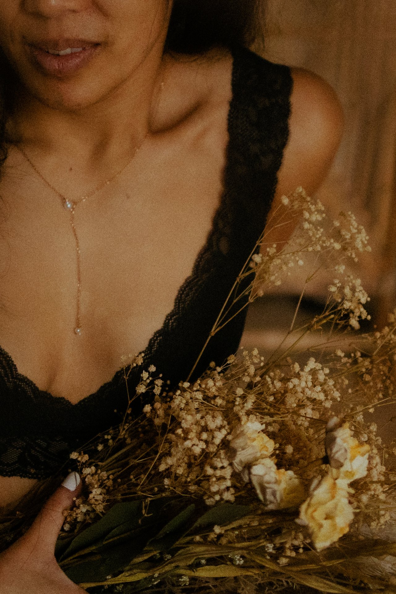 Portrait intimiste d une femme avec collier fin et fleurs sechees gypsophile en lumiere doree chaude - Melissa Jai Photographe