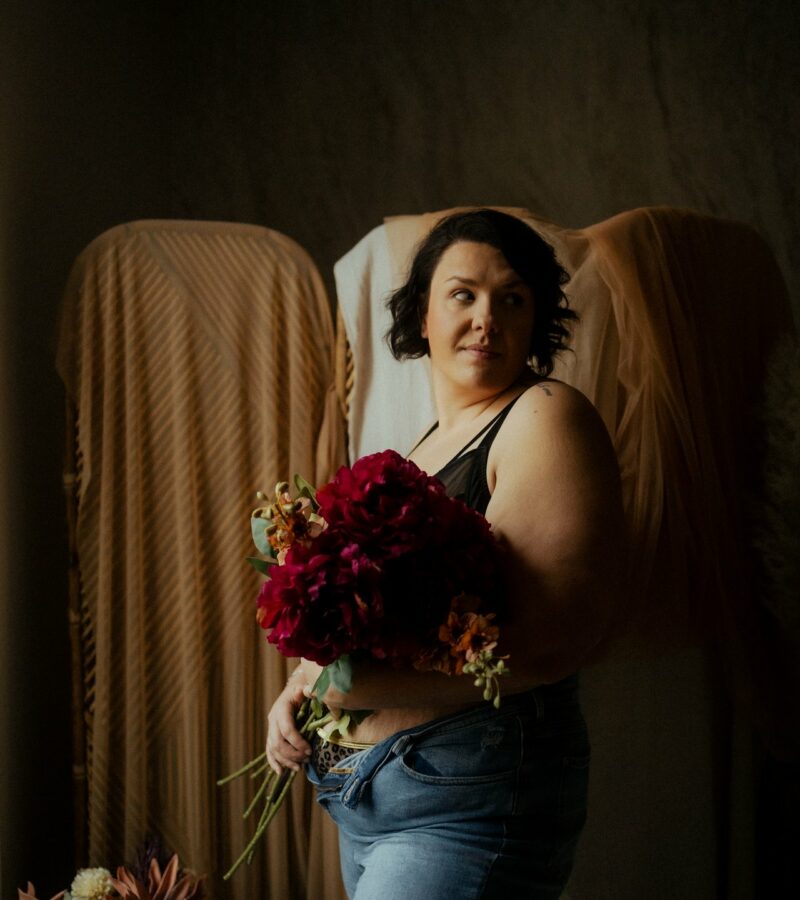 Portrait intimiste d une femme allongee avec une fleur rouge en lumiere naturelle douce - Melissa Jai Photographe