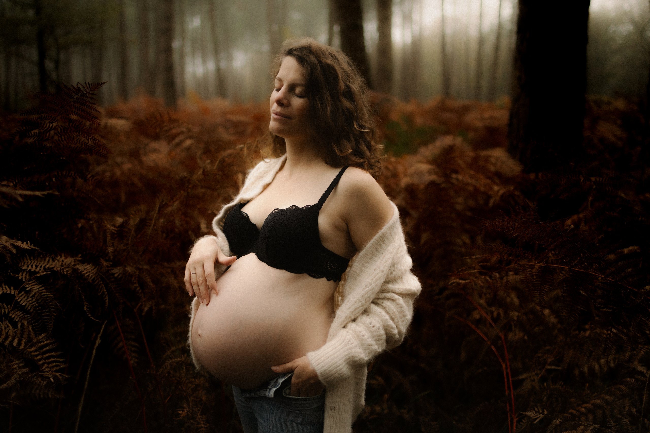 Femme enceinte posant en exterieur dans un decor automnal lors d'une seance grossesse - Melissa Jai Photographe