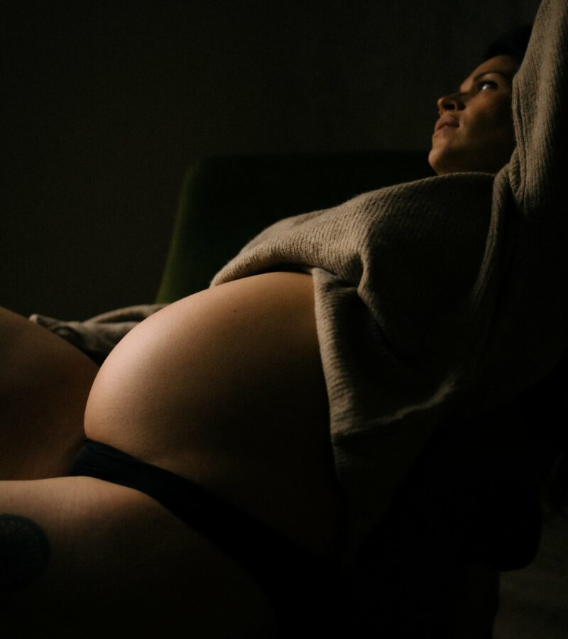 Portrait artistique en clair-obscur d'une femme enceinte en studio lors d'une séance grossesse - Melissa Jai Photographe