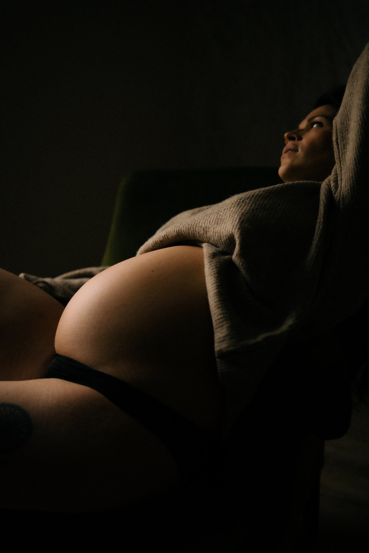 Portrait artistique en clair-obscur d'une femme enceinte en studio lors d'une séance grossesse - Melissa Jai Photographe