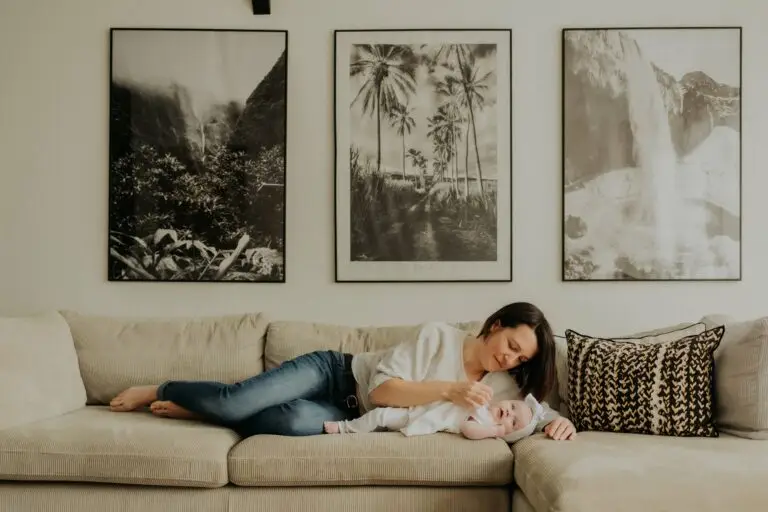 Maman allongée sur le canapé avec son bébé lors d'une séance naissance lifestyle à domicile - Melissa Jai Photographe
