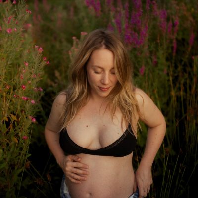 Femme enceinte dans un champ de fleurs violettes lors d'une seance grossesse en exterieur - Melissa Jai Photographe