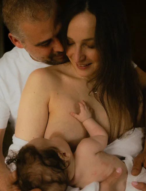 Parents tenant leur nouveau-né dans les bras lors d'une séance naissance en studio - Melissa Jai Photographe