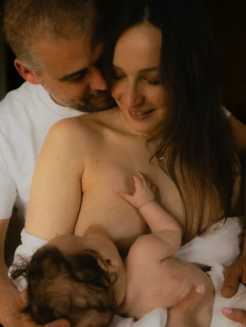 Parents tenant leur nouveau-né dans les bras lors d'une séance naissance en studio - Melissa Jai Photographe